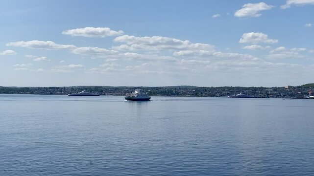 Ferry departing Horten on a sunny summer day with the harbour and Horten city in the background