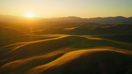 Obraz premium Golden sunrise over rolling hills, soft gradients of light on natural terrain, serene landscape for relaxation and inspiration.