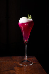 Exquisite Cocktail Creation With Vibrant Colors and Frothy Top Presented Elegantly on a Dark Wooden Table