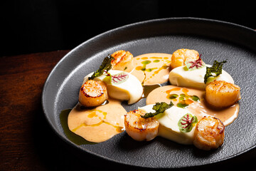 Gourmet Dining Experience Featuring Seared Scallops With Creamy Sauce and Elegant Presentation Perfect for a Luxurious Evening in a Fine Restaurant
