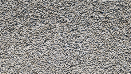 The texture of an asphalt road is characterized by its rough, gritty surface, providing good traction for vehicles and durability, making it suitable for various weather conditions and heavy traffic.
