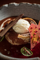 Decadent Dessert Creation Featuring Chocolate Cake, Creamy Ice Cream, Vibrant Sauce, and Artistic Garnishes at an Upscale Dining Venue in the Evening