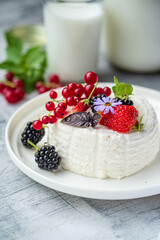 Delicate Dessert Adorned With Fresh Berries and Edible Flowers on a Rustic Table