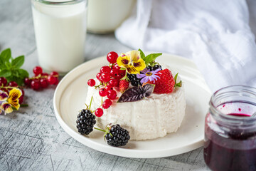 Delightful Dessert Featuring Fresh Berries and Edible Flowers on a Sunlit Table in a Cozy Kitchen Setting