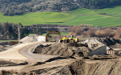 A processing facility for extracting and refining construction sand and gravel from a riverbed