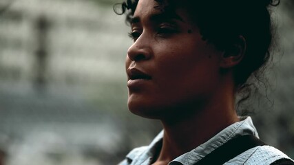 One meditative young black woman taking a deep breath close-up face standing outside during sunset time. Contemplative person trying to relax