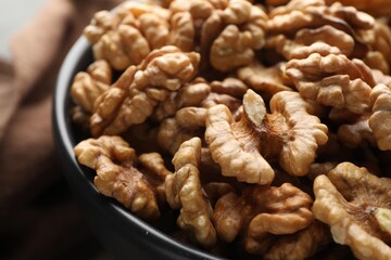 Fresh ripe walnuts in bowl on table, closeup