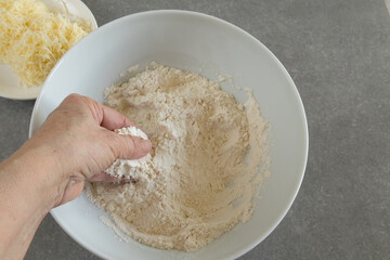 A hand mixes the flour with the salt.