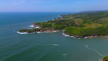 Bird eye view View of the coastline with hills and trees, cliffs, coral reefs and waves from the sea at Parang Ratjuk Gunung Kidul Yogyakarta