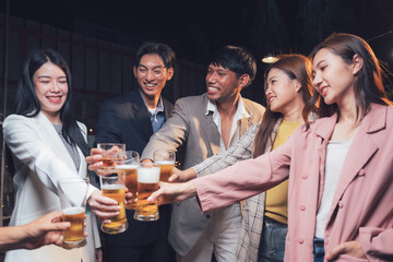 Cheers to Friendship: A diverse group of young adults raise their beer glasses in a celebratory...