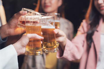 Cheers to Friendship: A group of diverse friends raise their glasses in a toast, celebrating togetherness and good times. The warm light of the bar illuminates their smiles.