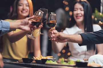 Cheers to Friendship: Close-up shot of friends raising wine glasses in a toast, celebrating...