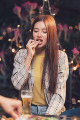 Casual Drinks with Friends:  A young woman enjoys a casual night out with friends, savoring a...