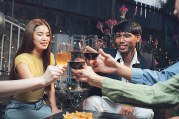 Nightlife Cheers: Friends raise their wine glasses in a celebratory toast, enjoying an evening of laughter and companionship at an outdoor restaurant.