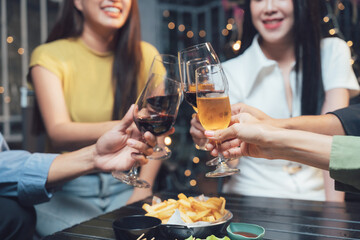 Cheers to Friendship: A group of friends raise their glasses in a celebratory toast, sharing laughter and good company over drinks and appetizers in a warm and inviting setting.