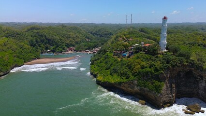 Drone view of the beach and traditional harbor in the middle of coral hills with many traditional fishing boats at Baron Beach, Gunung Kidul, Yogyakarta