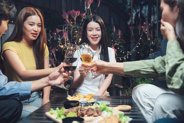 Nighttime Cheers: Friends raise a toast, sharing laughter and good times over drinks and a delicious meal in a cozy, dimly lit setting.  
