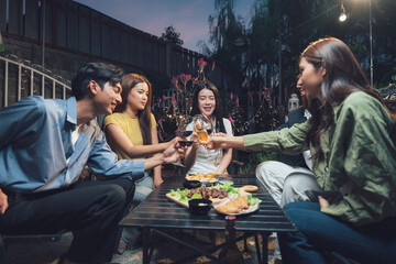Nighttime Backyard Gathering: Friends raise a toast, sharing laughter and good times during a lively evening gathering in a backyard setting.