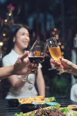 Cheers to Good Times: Close up of two hands clinking wine glasses during a celebratory dinner.
