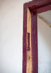 Worker repair warped wooden doorframe be straightened out and made usable again.