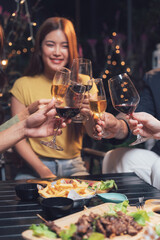 Nighttime Cheers: Friends raise their wine glasses in a celebratory toast, enjoying a delightful dinner and lively conversation under warm, inviting lights.