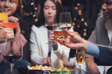 Cheers to Connection: Friends raise their glasses in a celebratory toast, surrounded by the warm ambiance of a lively gathering.  The scene is filled with laughter, camaraderie.