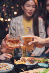 Cheers to Friendship: Close-up shot of friends toasting with beer and whiskey, enjoying a lively...