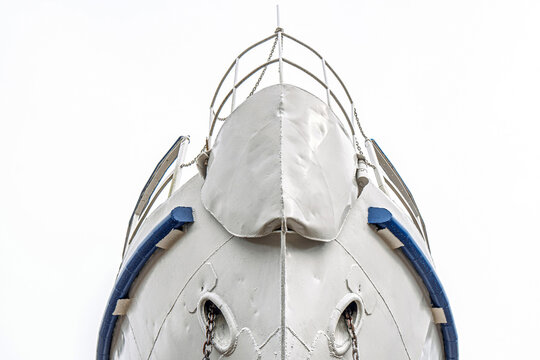 Ship's bow with anchor chains extending from the hawse holes, featuring weathered metal and welded seams close view