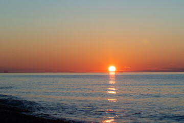 Sunset at sea, beach waves and golden sunlight, tropical scene with scenic horizon.