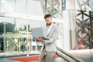 Fototapeta premium Modern businessman outdoors, using a tablet. Ideal for business, technology, and innovation themes.