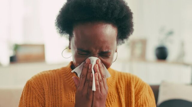Black woman, blowing nose or virus with tissue for sneeze, viral infection or sinus on sofa at home. Female person, flu or sick with allergy or influenza for hayfever, illness or disease at house