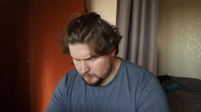 Angry man working on laptop, contempt for technology issues, working on freelance project.