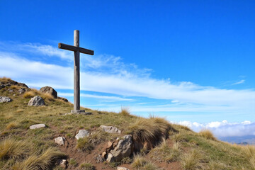 large weathered wooden cross on grassy hill blue sky