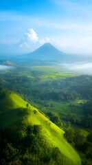 Fototapeta premium Lush green fields with scenic mountain views under a clear blue sky, perfect for agricultural articles, environmental campaigns, or travel promotions.