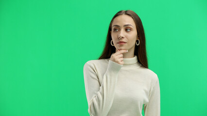 Fototapeta premium A woman, close-up, on a green background, thinks