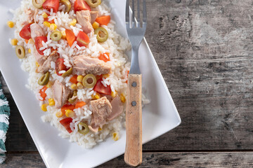 Rice salad with tomato, corn,olives and tuna on wooden table. Top view. Copy space