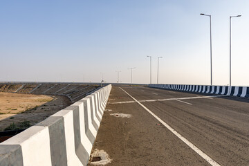 Fototapeta premium isolated empty tarmac road with bright sunset sky at evening