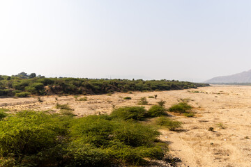 arid riverbed with mountains in the background under daylight
