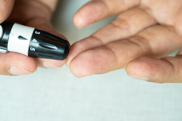 Woman's hands checking diabetes and hyperglycemia with digital blood sugar meter. Healthcare and medical concept	
