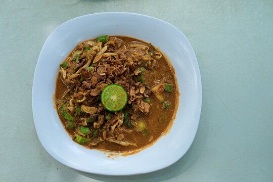 A plate of Karedok, a traditional Indonesian raw vegetable salad with peanut sauce, topped with fried shallots and fresh lime. A flavorful, crunchy, and healthy Sundanese dish