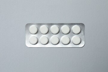 Pills in blister pack on gray  background, close up