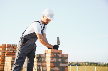 Construction worker man in work clothes and a construction helmet. Portrait of positive male...