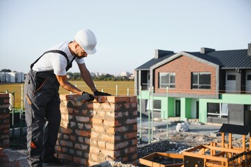 Construction worker in uniform and safety equipment have job on building. Industrial theme