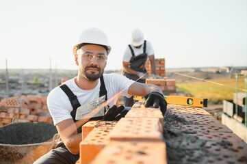Construction worker man in work clothes and a construction helmet. Portrait of positive male...