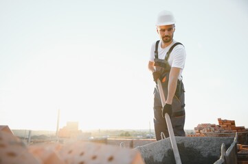 Construction worker in uniform and safety equipment have job on building