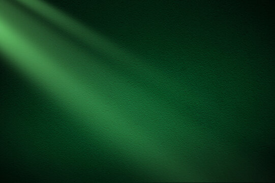 Green light rays on dark green background. Abstract green light background.