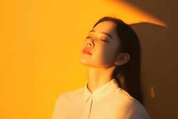 woman with closed eyes bathed in golden light