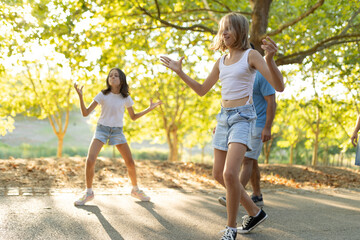 Obraz premium Teenagers dancing outdoors in sunlit park