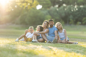 Happy family relaxing together in sunny park