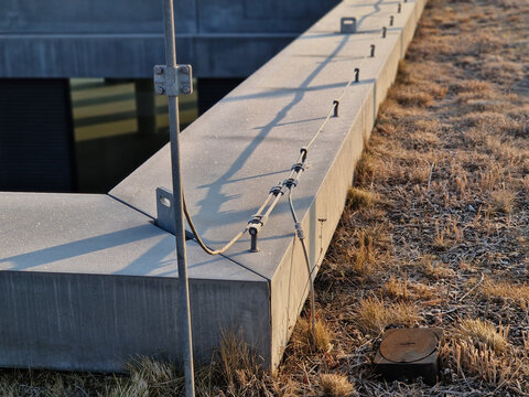 lightning conductor is used to protect buildings from lightning that can damage electrical equipment is routed to the highest points of a green garden roof. screwed to the edge of attic, control box